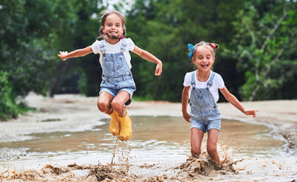 Image: Adobe Stock Twin girls jumping in a stream